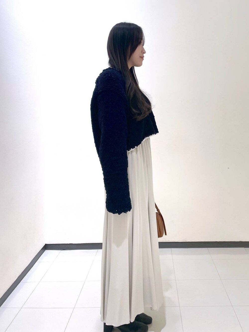 ホワイト系のスカート、ブルー系のニット/セーターを着用したレディースの冬コーディネートの2枚目の写真