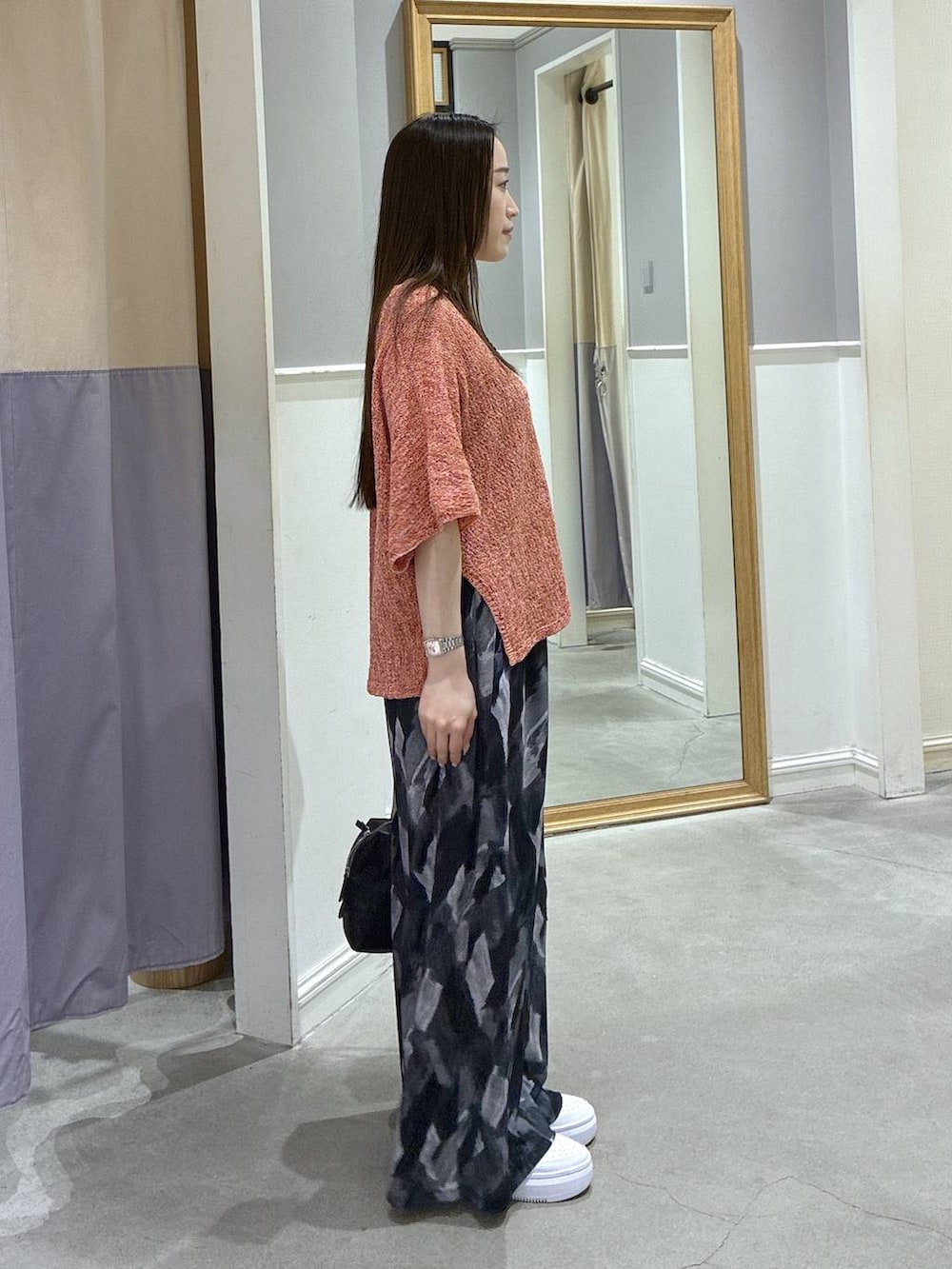 グレー系のその他パンツ、ブラック系のボストンバッグ、レッド系のニット/セーターを着用したレディースの春コーディネートの2枚目の写真