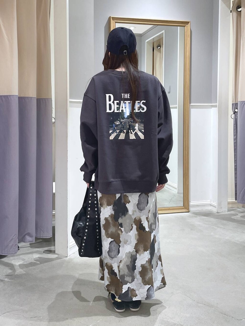 ブラック系のハンドバッグ、ブラウン系のスカート、グレー系のスウェットを着用したレディースの秋コーディネートの4枚目の写真