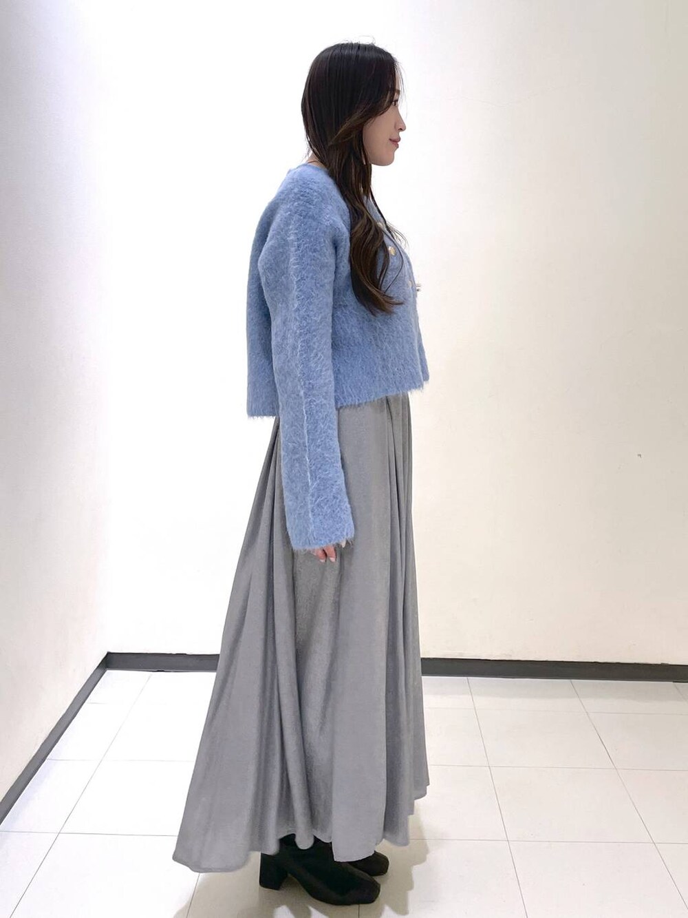 ブルー系のカーディガン/ボレロ、グレー系のスカートを着用したレディースの冬コーディネートの2枚目の写真