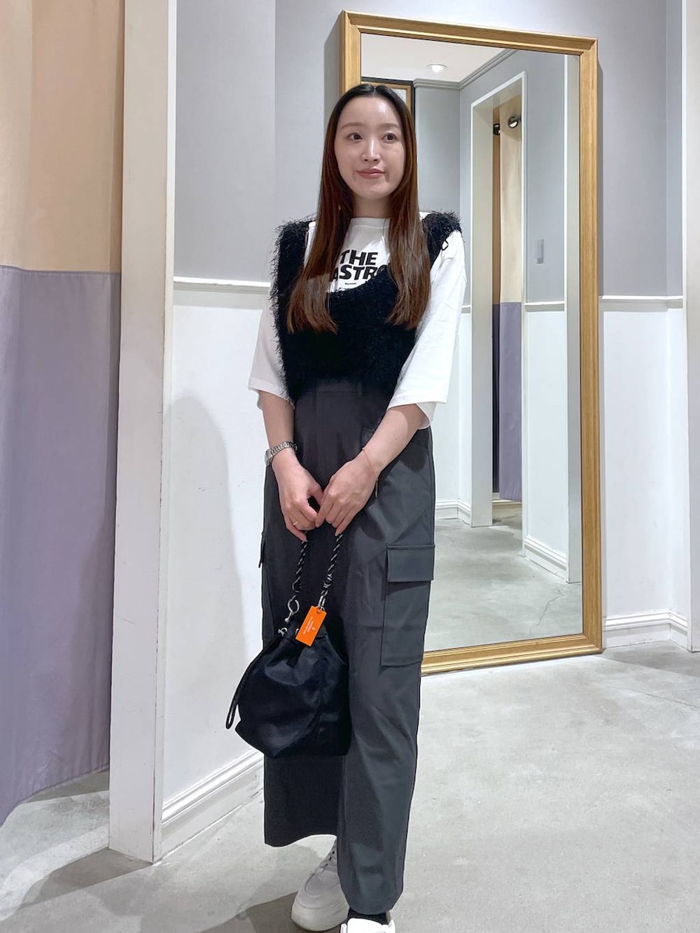 ホワイト系のTシャツ/カットソー、ブラック系のショルダーバッグ、グレー系のスカートを着用したレディースの秋コーディネートの2枚目の写真