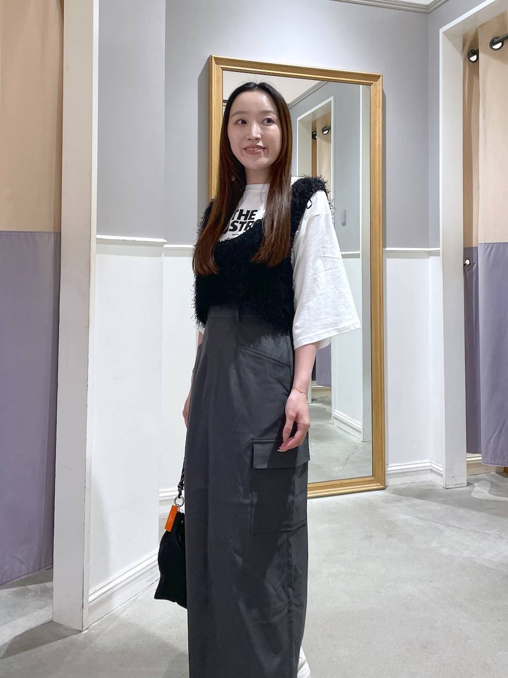 ホワイト系のTシャツ/カットソー、ブラック系のショルダーバッグ、グレー系のスカートを着用したレディースの秋コーディネートの4枚目の写真