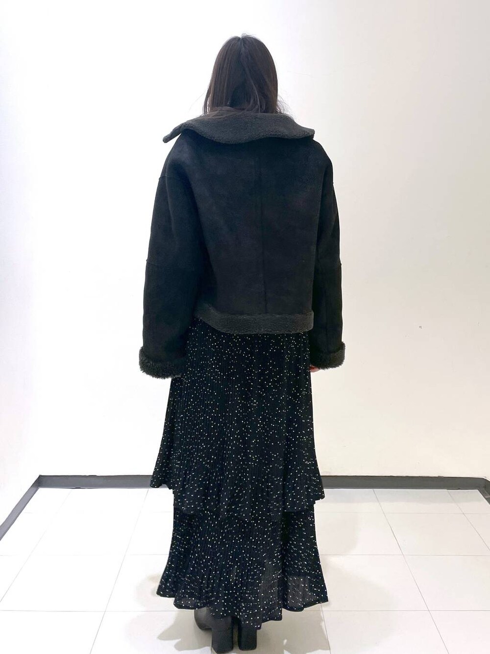 グレー系のスカート、グレー系のブルゾンを着用したレディースの冬コーディネートの3枚目の写真