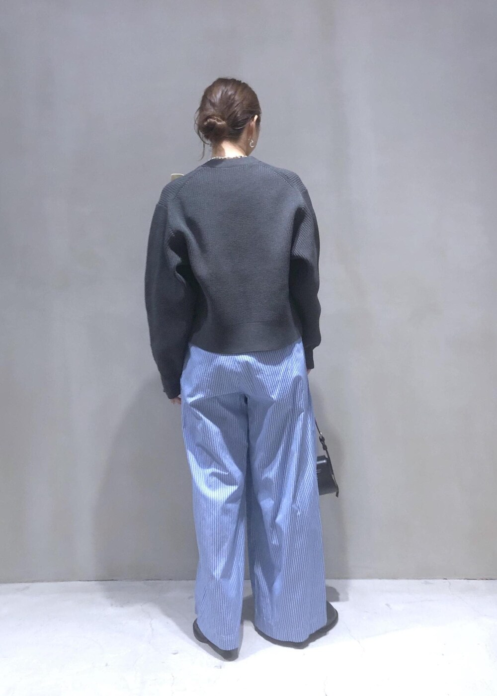 ブラック系のサンダル、グレー系のカーディガン/ボレロ、ブルー系のスラックスを着用したレディースの秋コーディネートの4枚目の写真