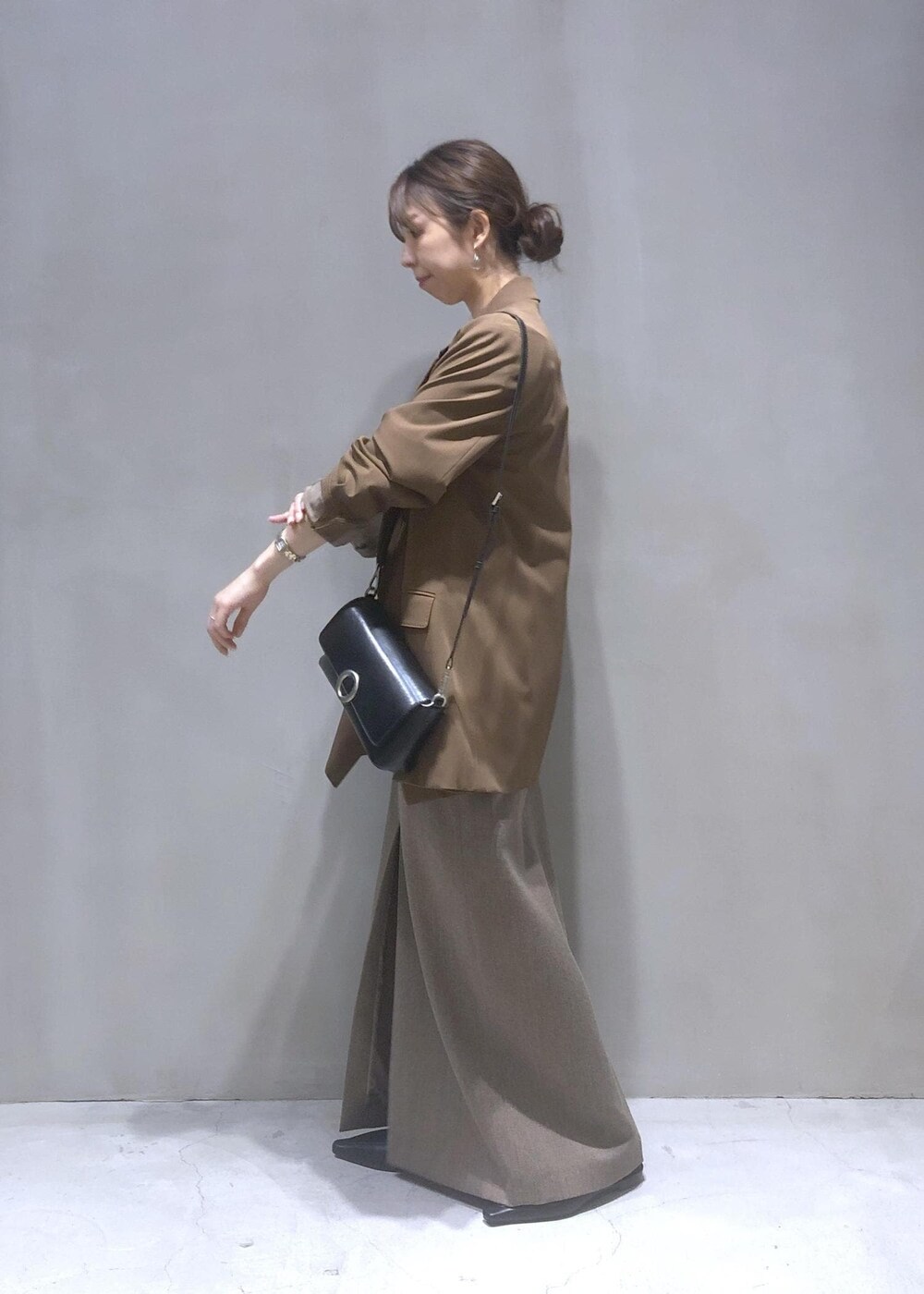 ブラック系のサンダル、ブラック系のショルダーバッグ、ブラウン系のテーラードジャケットを着用したレディースの秋コーディネートの2枚目の写真