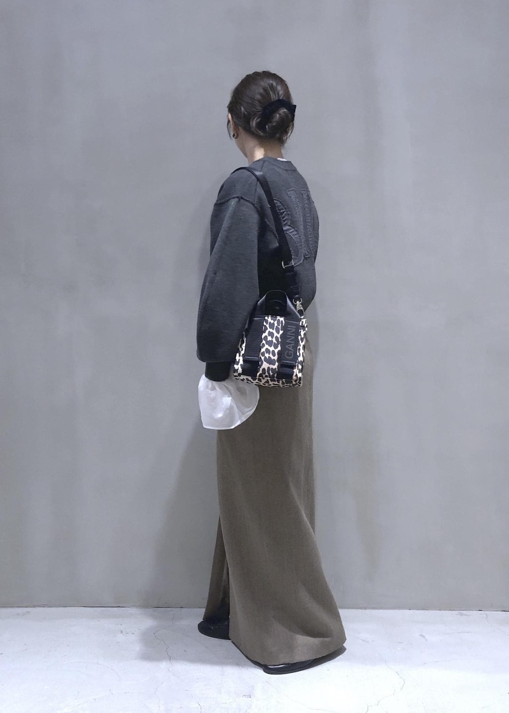 ベージュ系のスカート、グレー系のニット/セーターを着用したレディースの秋コーディネートの3枚目の写真