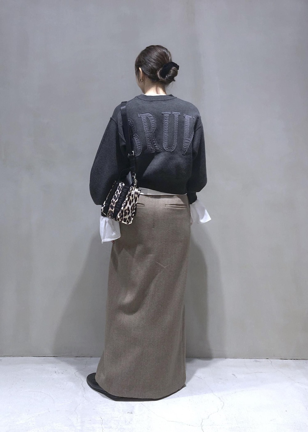 ベージュ系のスカート、グレー系のニット/セーターを着用したレディースの秋コーディネートの4枚目の写真