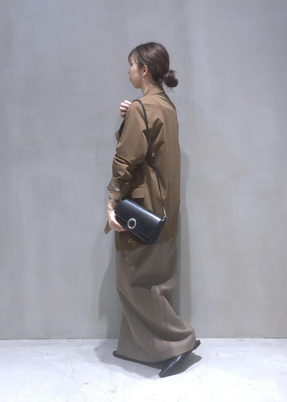 ブラック系のサンダル、ブラック系のショルダーバッグ、ブラウン系のテーラードジャケットを着用したレディースの秋コーディネートの3枚目の写真