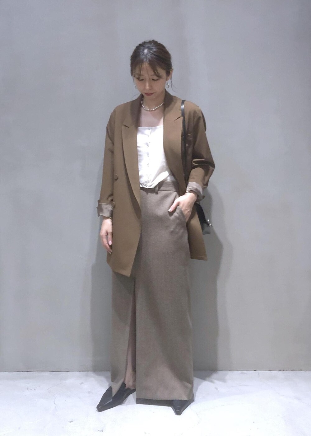 ブラック系のサンダル、ブラック系のショルダーバッグ、ブラウン系のテーラードジャケットを着用したレディースの秋コーディネートの6枚目の写真