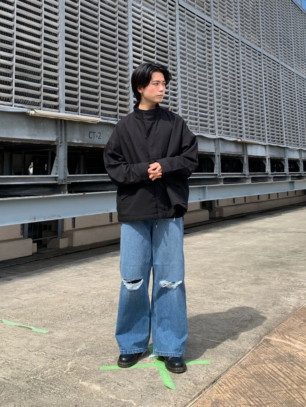 ブラック系のブルゾン、ブルー系のデニムパンツ、ブラック系のドレスシューズを着用したメンズの秋コーディネートの3枚目の写真