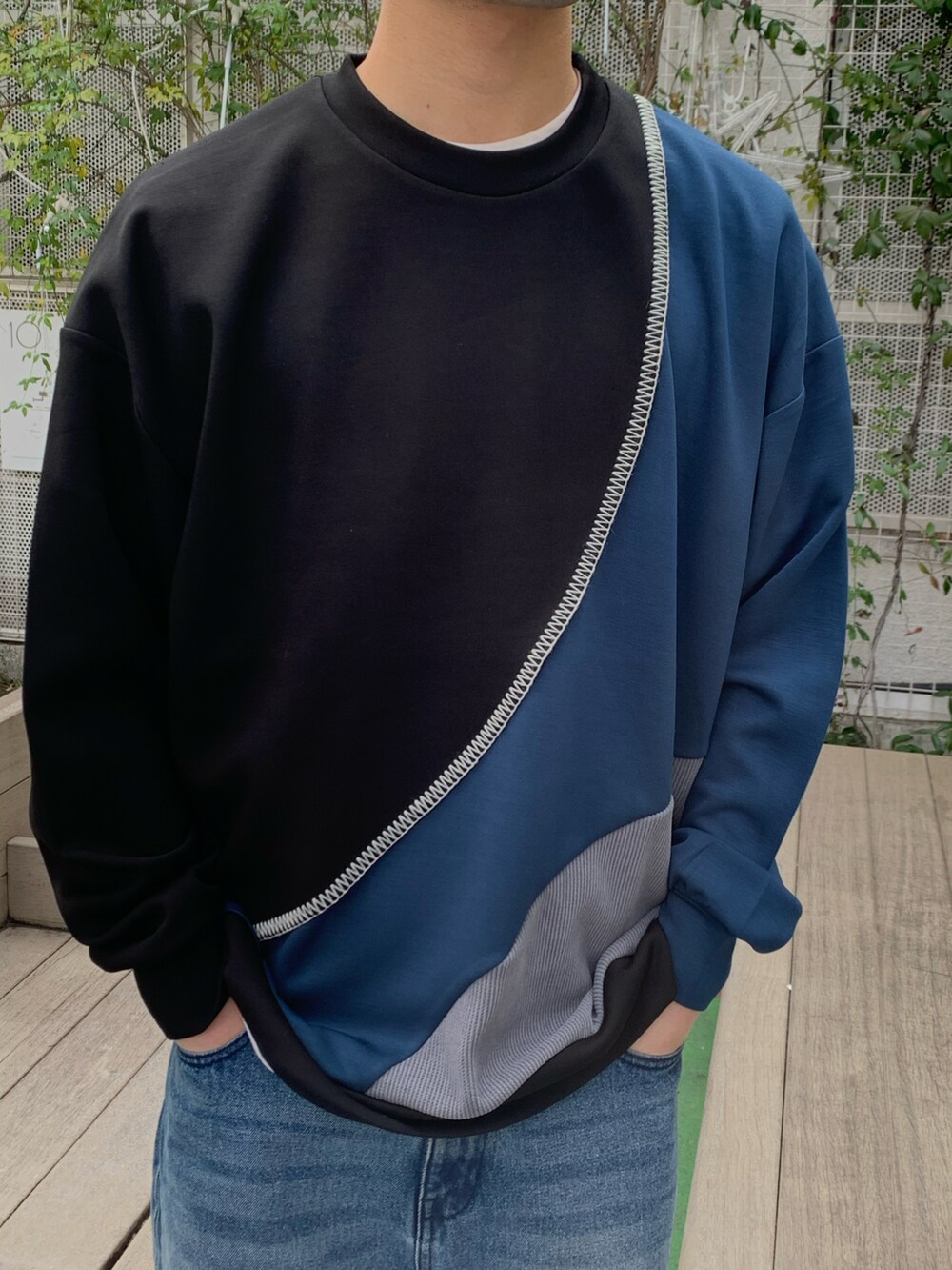 ブルー系のTシャツ/カットソー、ブルー系のデニムパンツ、ホワイト系のスニーカーを着用したメンズの冬コーディネートの2枚目の写真