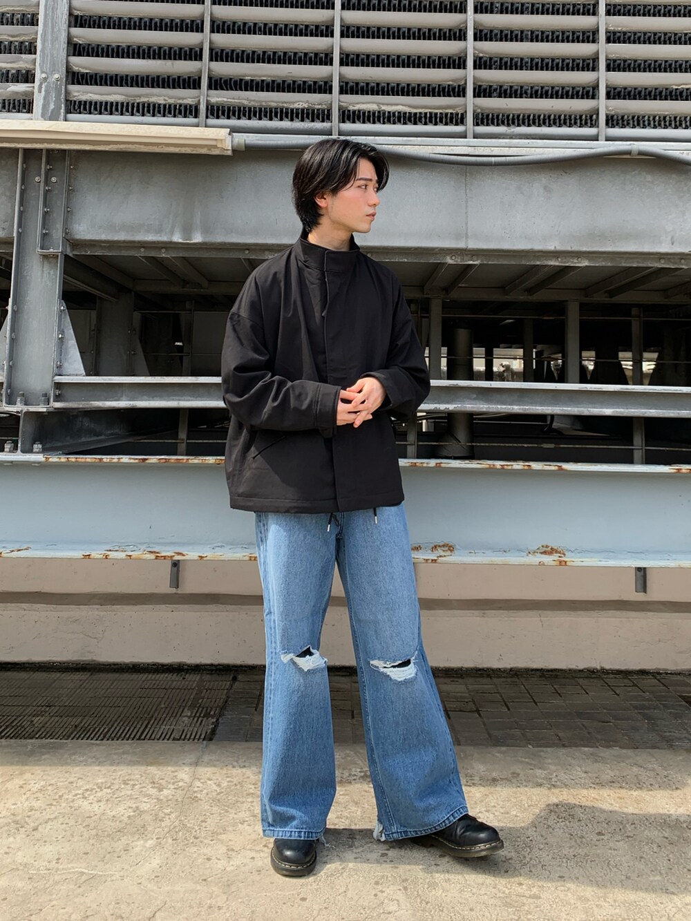 ブラック系のブルゾン、ブルー系のデニムパンツ、ブラック系のドレスシューズを着用したメンズの秋コーディネートの2枚目の写真