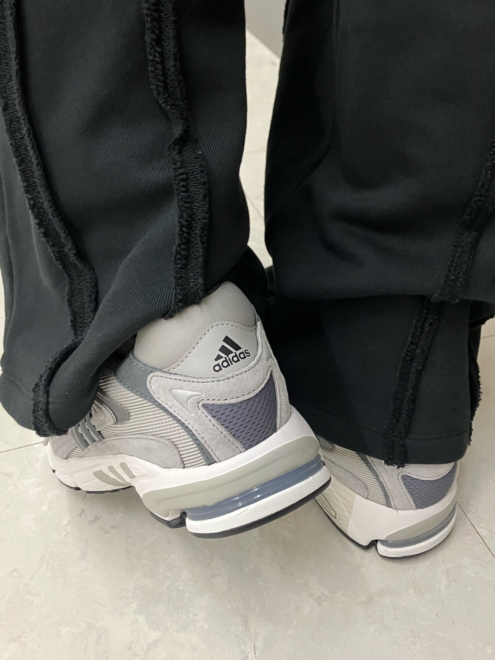 ブラック系のポロシャツ、グレー系のスニーカー、ブラック系のニットキャップ/ビーニーを着用したメンズの春コーディネートの5枚目の写真