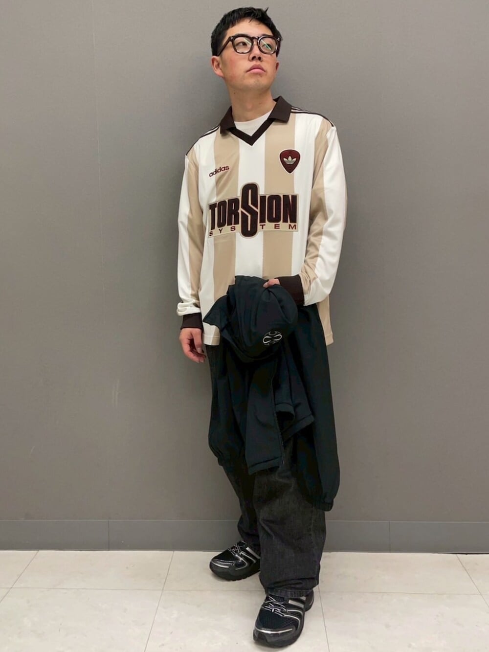 ブラック系のジャージ、ホワイト系のTシャツ/カットソー、ブラック系のスニーカーを着用したメンズの冬コーディネートの3枚目の写真