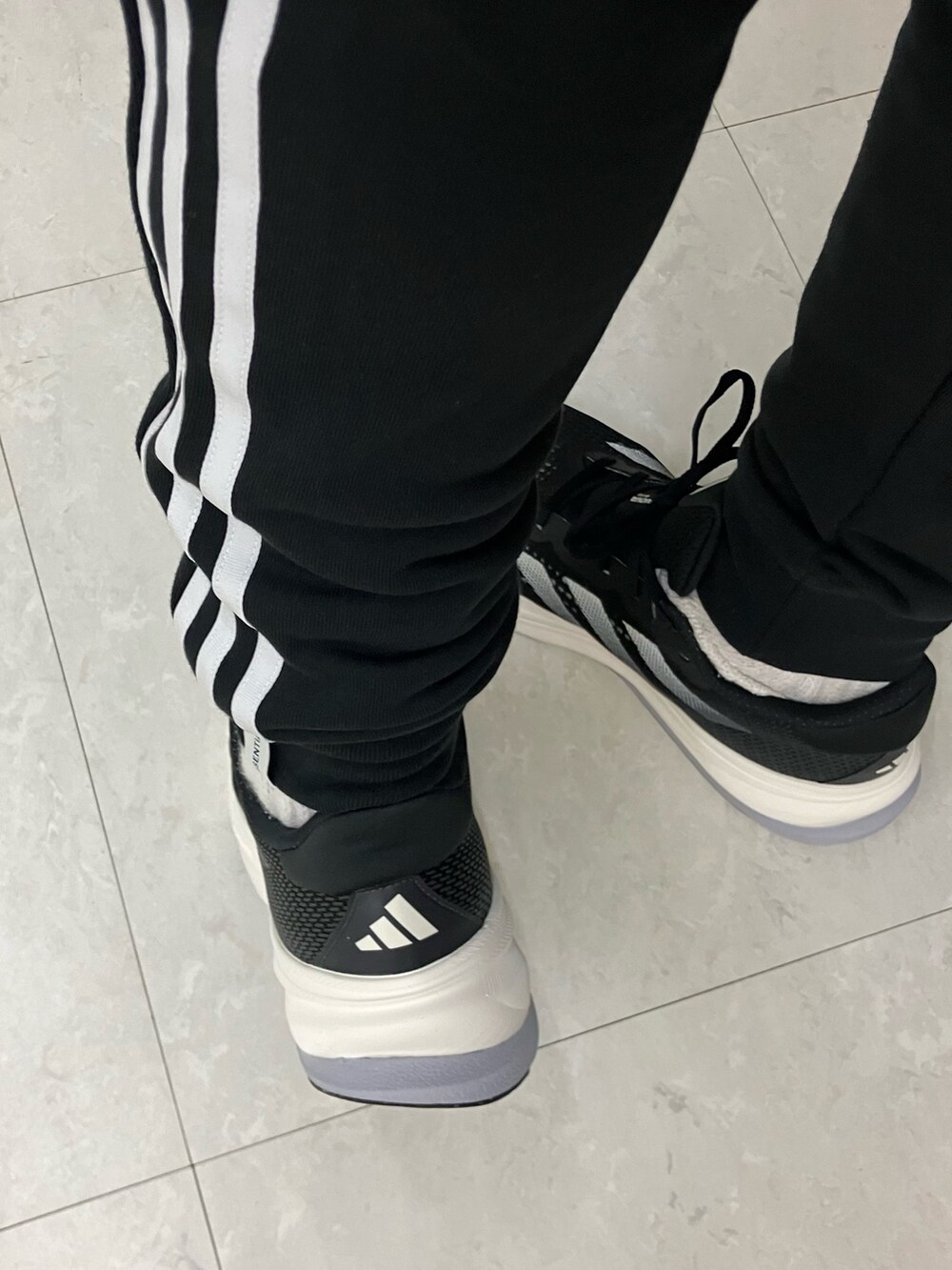 グリーン系のパーカー、ブラック系のスウェットパンツ、ブラック系のスニーカーを着用したメンズの春コーディネートの4枚目の写真