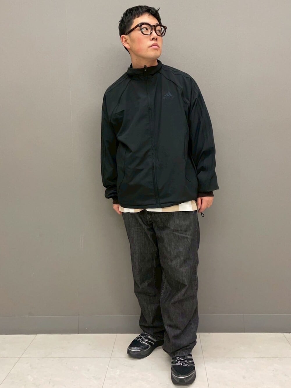 ブラック系のジャージ、ホワイト系のTシャツ/カットソー、ブラック系のスニーカーを着用したメンズの冬コーディネートの2枚目の写真