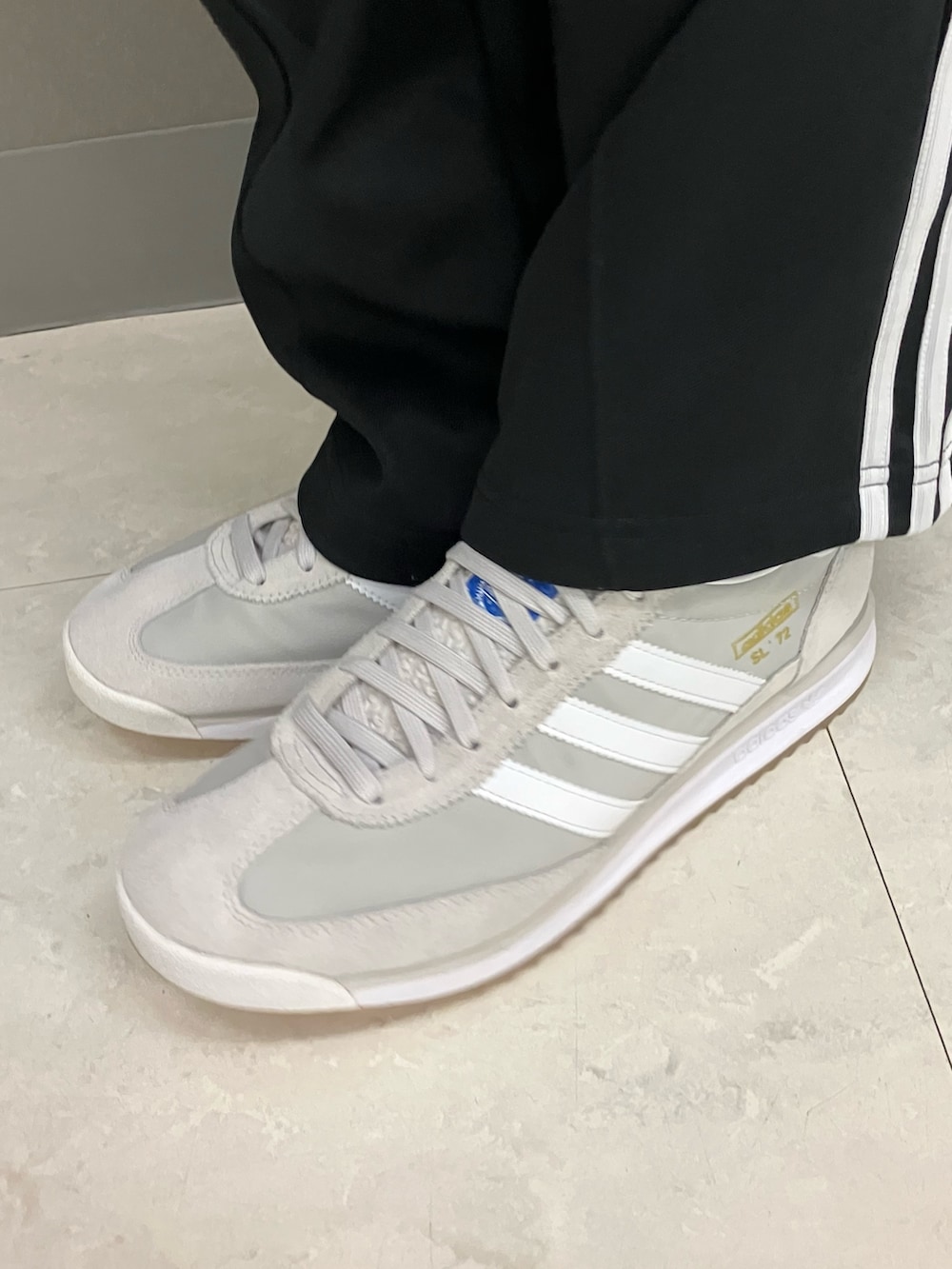 ホワイト系のジャケット/アウター、ブラック系のスウェットパンツ、グレー系のスニーカーを着用したメンズの冬コーディネートの2枚目の写真