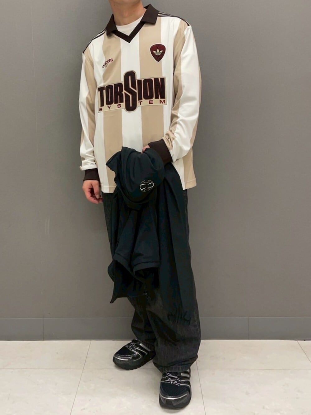 ブラック系のジャージ、ホワイト系のTシャツ/カットソー、ブラック系のスニーカーを着用したメンズの冬コーディネートの4枚目の写真