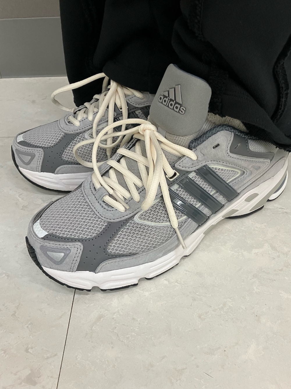 ブラック系のポロシャツ、グレー系のスニーカー、ブラック系のニットキャップ/ビーニーを着用したメンズの春コーディネートの4枚目の写真