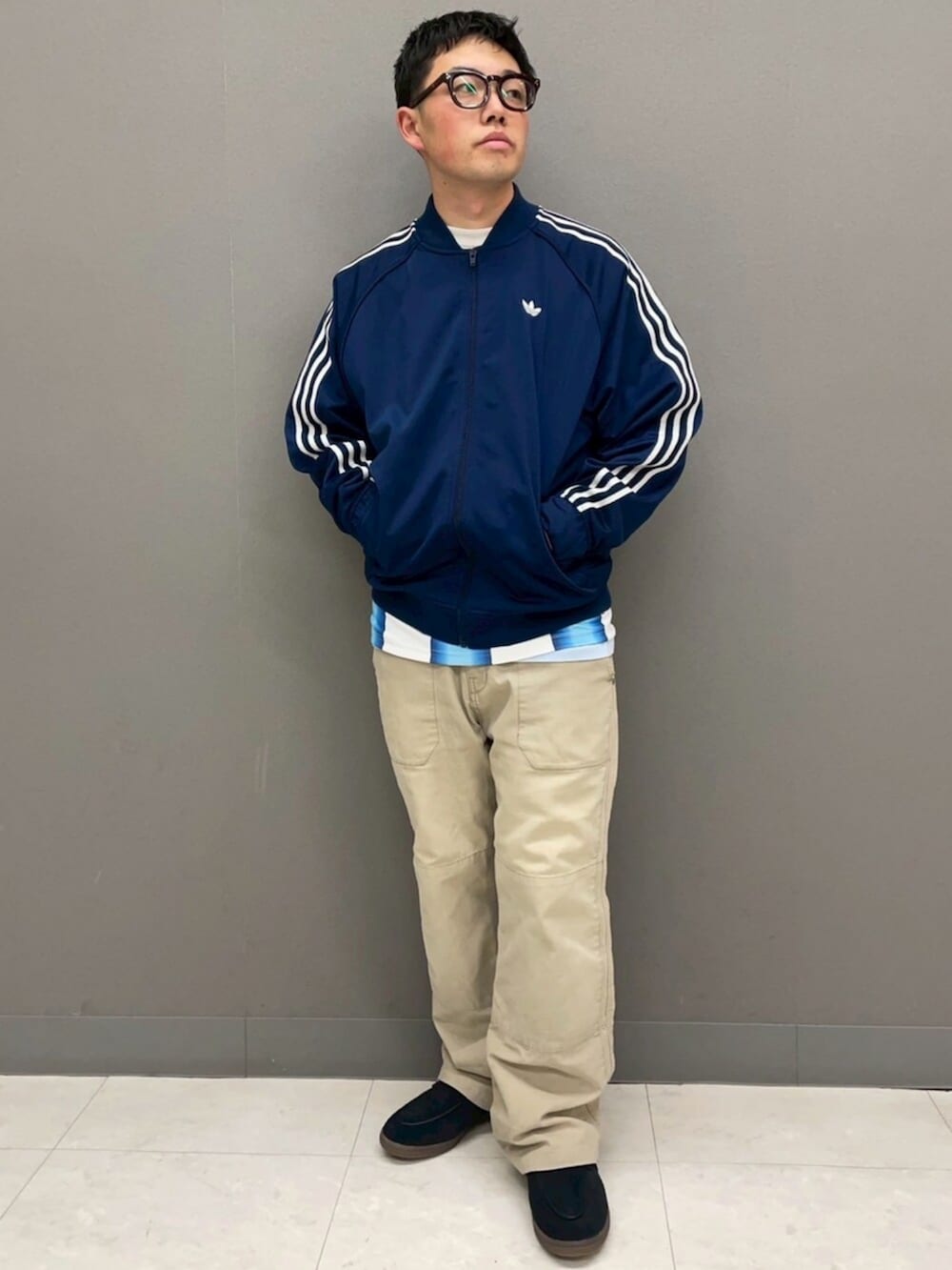 ホワイト系のトップス、ブルー系のジャージ、ブラック系のスニーカーを着用したメンズの春コーディネートの2枚目の写真