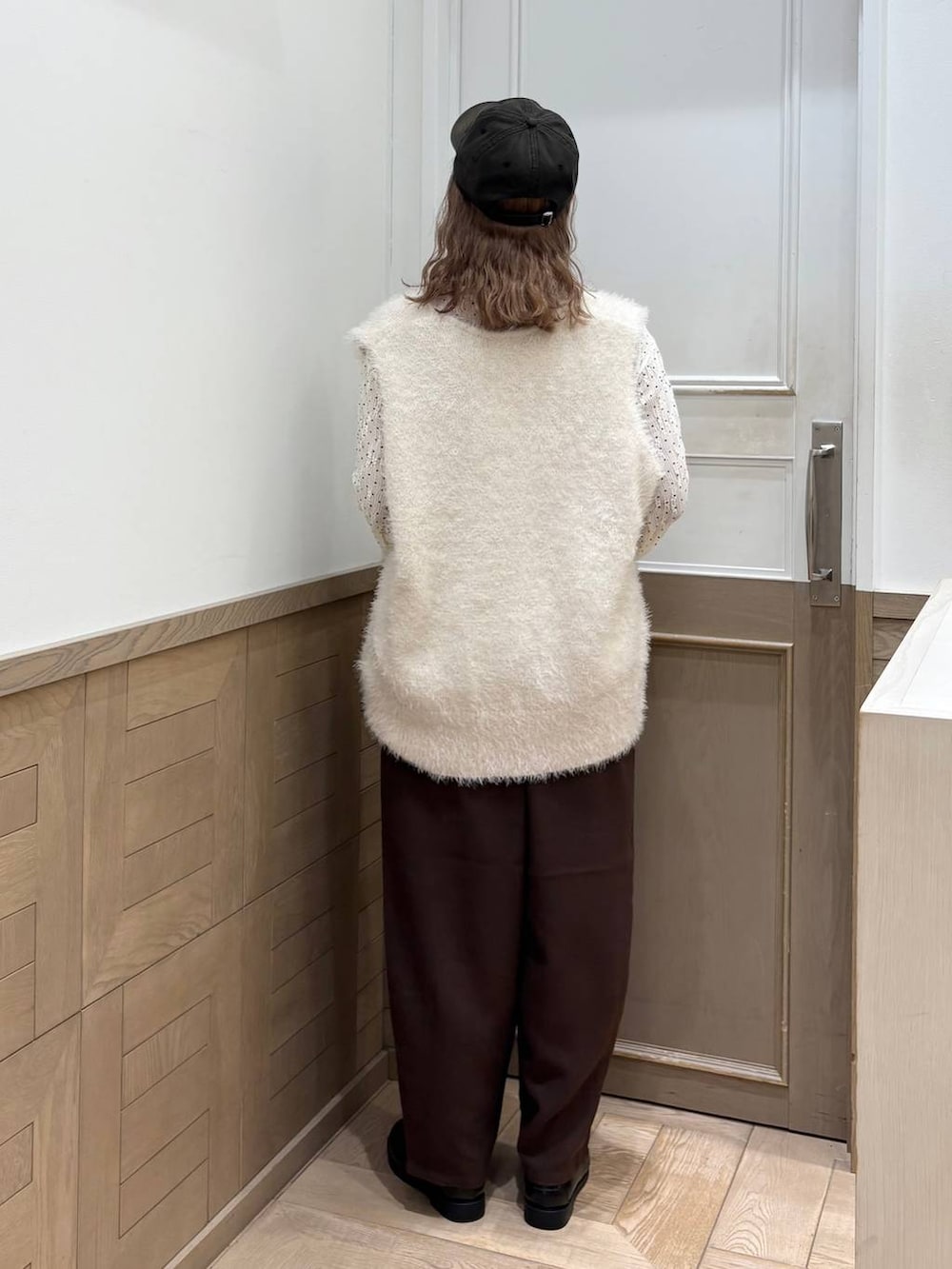 ブラウン系のその他パンツ、ホワイト系のベスト、ブラック系のローファーを着用したレディースの秋コーディネートの3枚目の写真