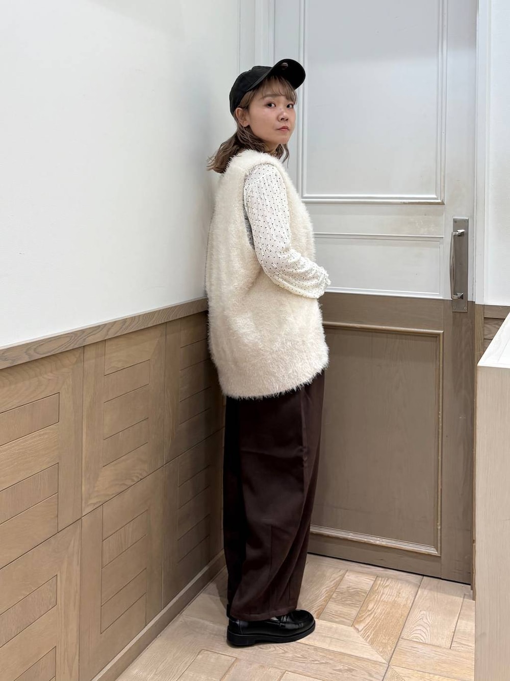 ブラウン系のその他パンツ、ホワイト系のベスト、ブラック系のローファーを着用したレディースの秋コーディネートの2枚目の写真