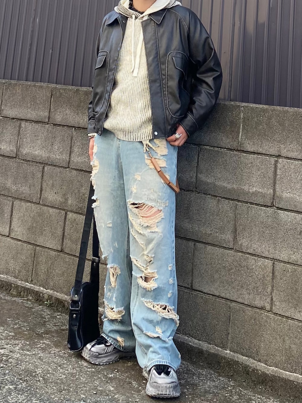 グレー系のブルゾン、ホワイト系のパーカー、ブルー系のデニムパンツを着用したメンズの春コーディネートの3枚目の写真