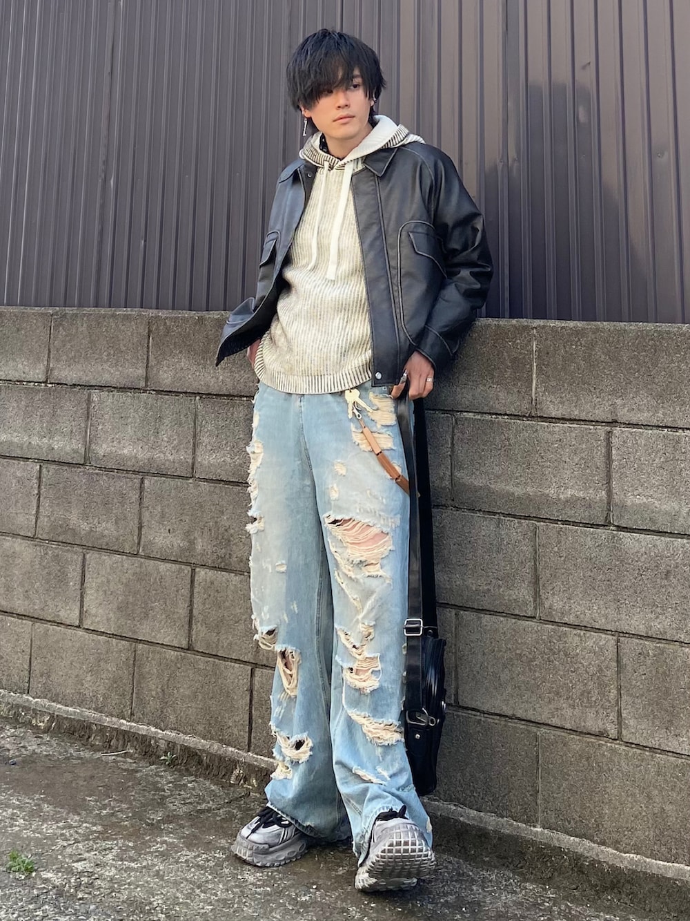 グレー系のブルゾン、ホワイト系のパーカー、ブルー系のデニムパンツを着用したメンズの春コーディネートの4枚目の写真