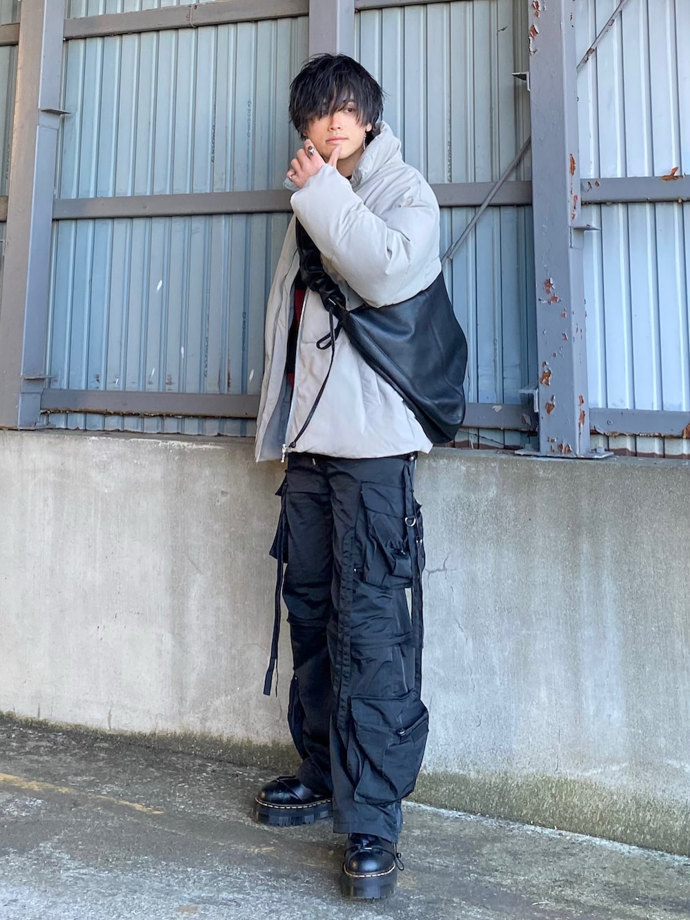 グレー系のダウンジャケット/コート、レッド系のニット/セーター、ブラック系のカーゴパンツを着用したメンズの冬コーディネートの5枚目の写真