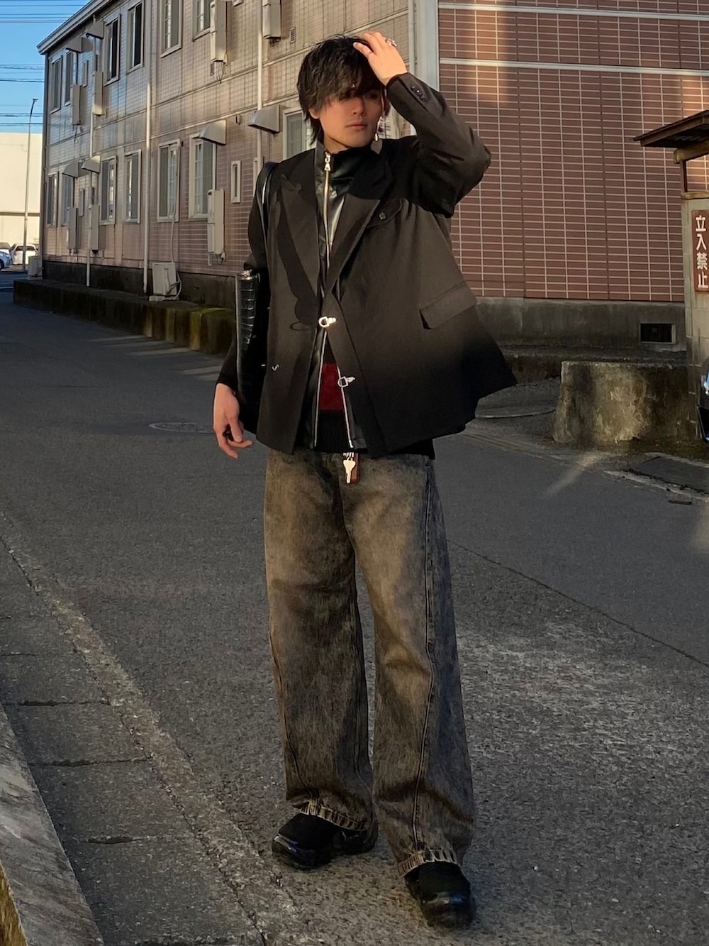 ブラック系のテーラードジャケット、ブラック系のベスト、レッド系のニット/セーターを着用したメンズの春コーディネートの4枚目の写真