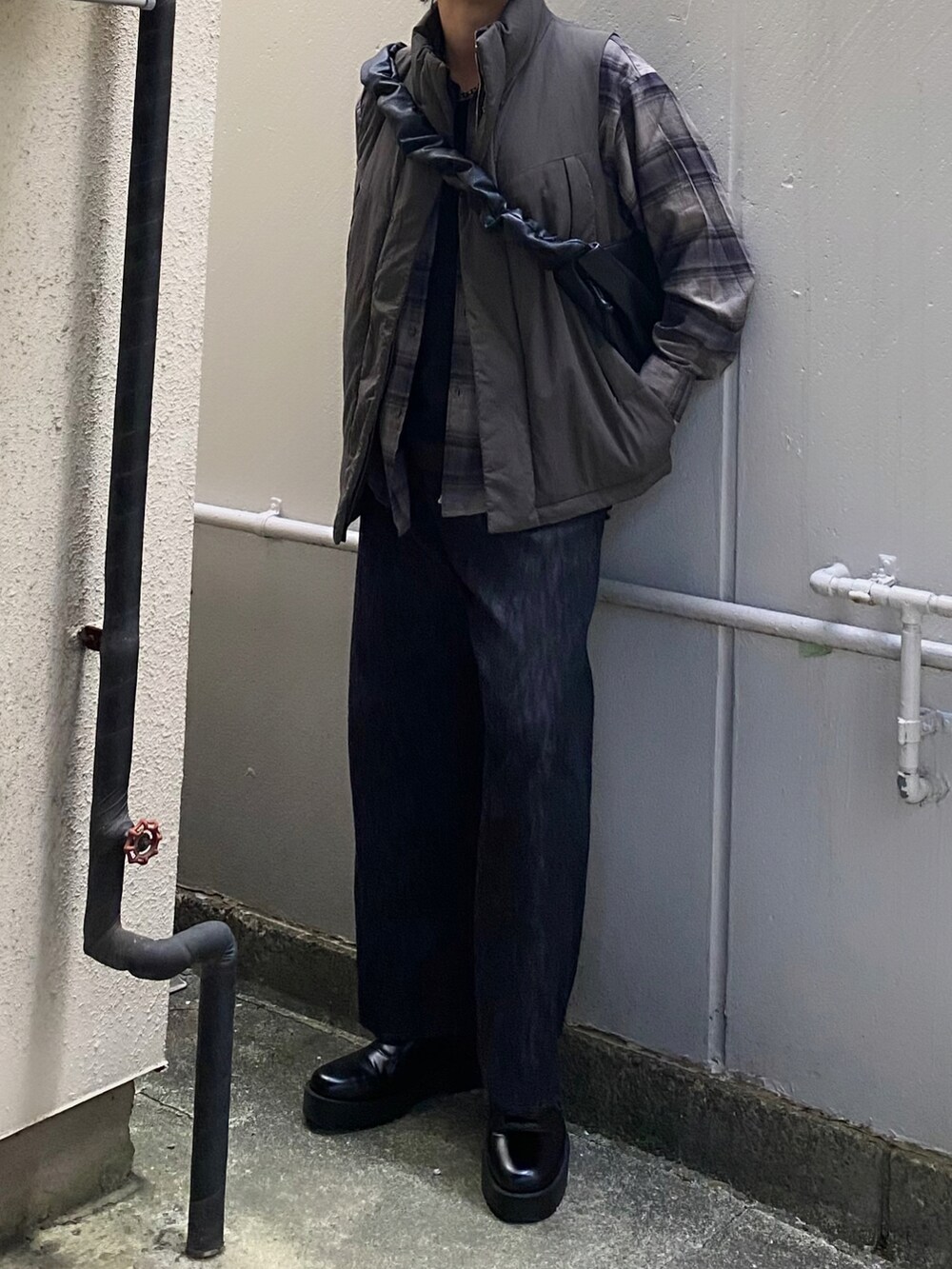 グリーン系のダウンベスト、グレー系のシャツ/ブラウス、ブラック系のタンクトップを着用したメンズの春コーディネートの3枚目の写真