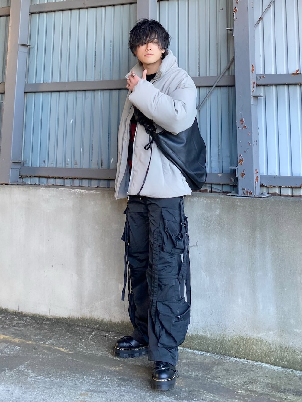 グレー系のダウンジャケット/コート、レッド系のニット/セーター、ブラック系のカーゴパンツを着用したメンズの冬コーディネートの2枚目の写真