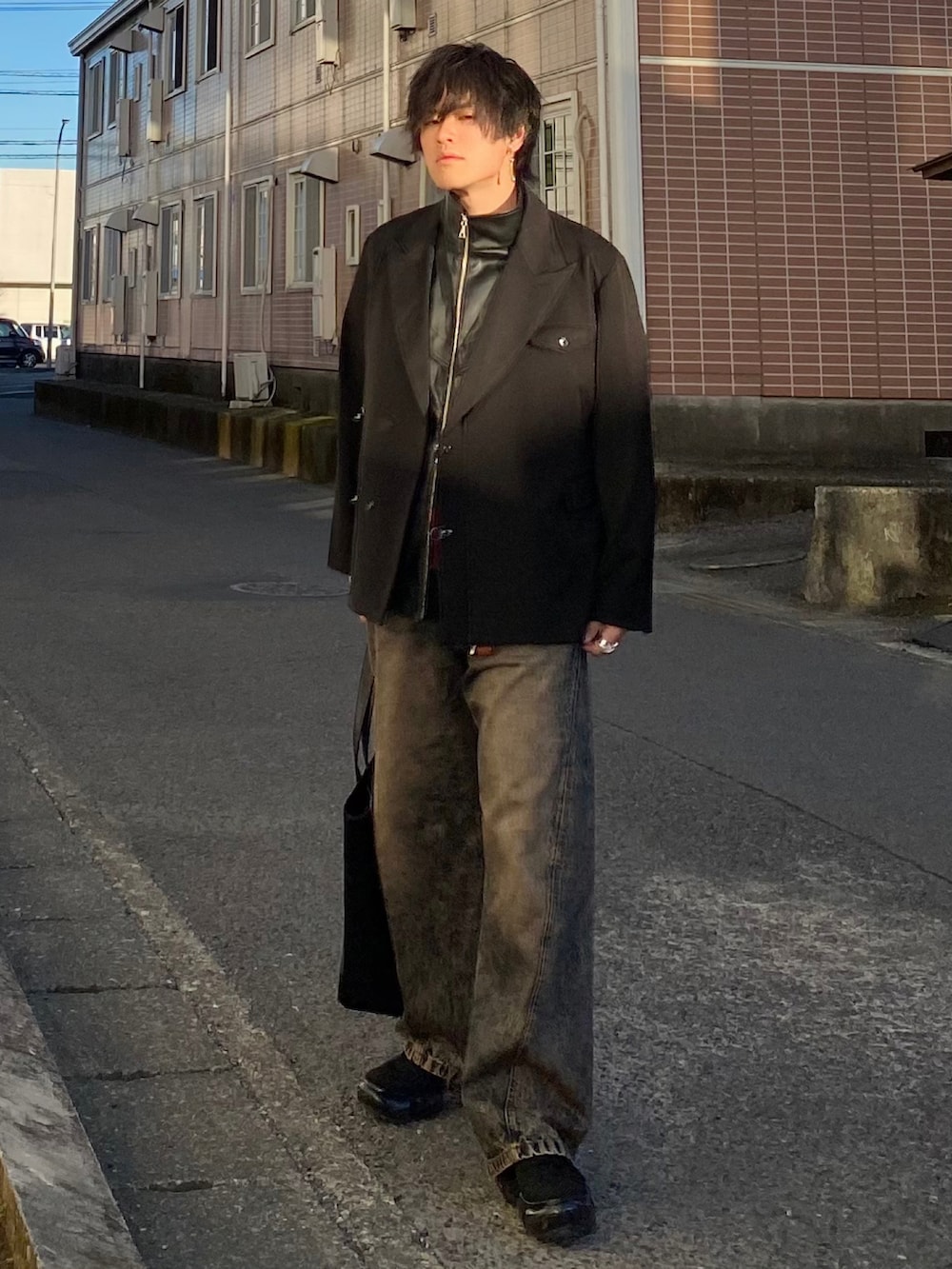 ブラック系のテーラードジャケット、ブラック系のベスト、レッド系のニット/セーターを着用したメンズの春コーディネートの2枚目の写真