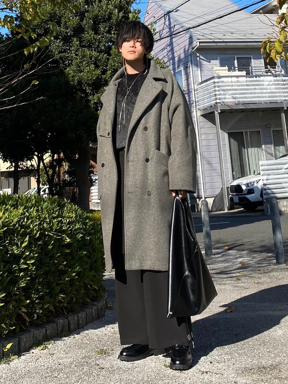 グレー系のトレンチコート、グレー系のニット/セーター、ブラック系のカーゴパンツを着用したメンズの冬コーディネートの5枚目の写真