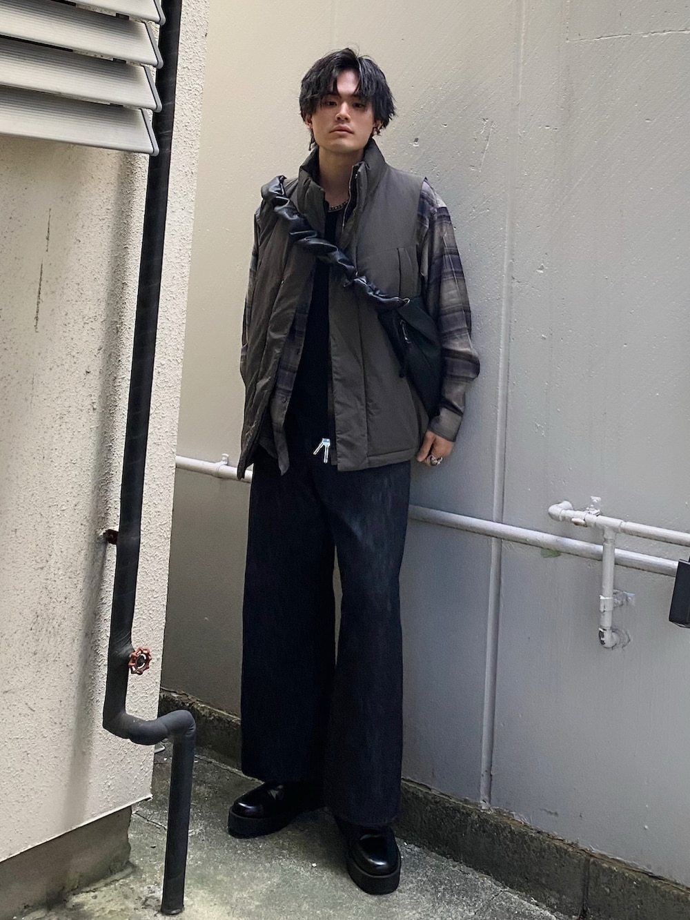 グリーン系のダウンベスト、グレー系のシャツ/ブラウス、ブラック系のタンクトップを着用したメンズの春コーディネートの2枚目の写真