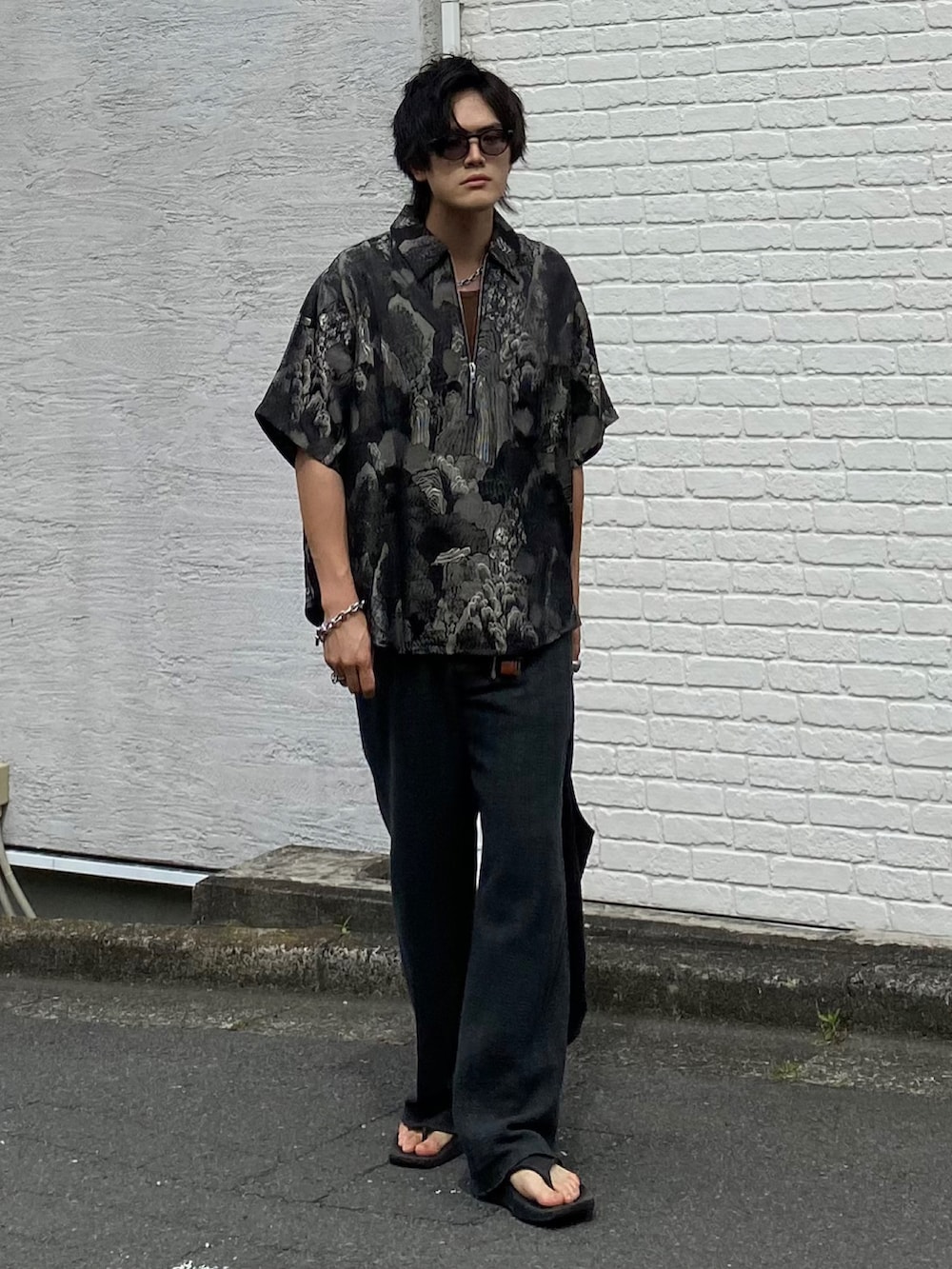 ブラック系のTシャツ/カットソー、ブラウン系のタンクトップ、グレー系のスラックスを着用したメンズの夏コーディネートの2枚目の写真