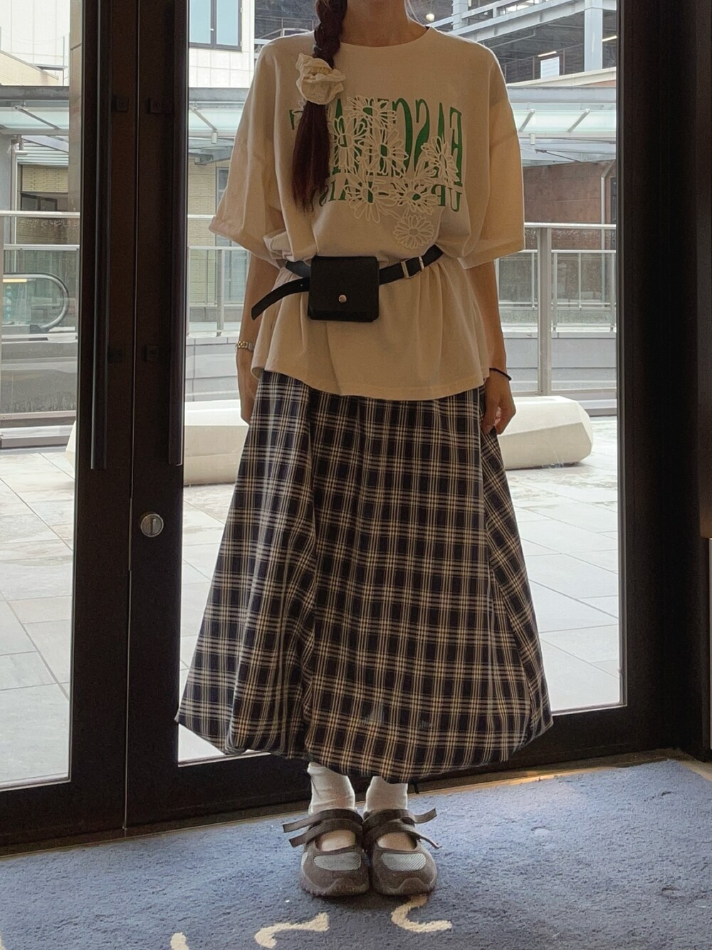 ブルー系のスカート、ベージュ系のTシャツ/カットソー、グレー系のスニーカーを着用したレディースの夏コーディネートの2枚目の写真