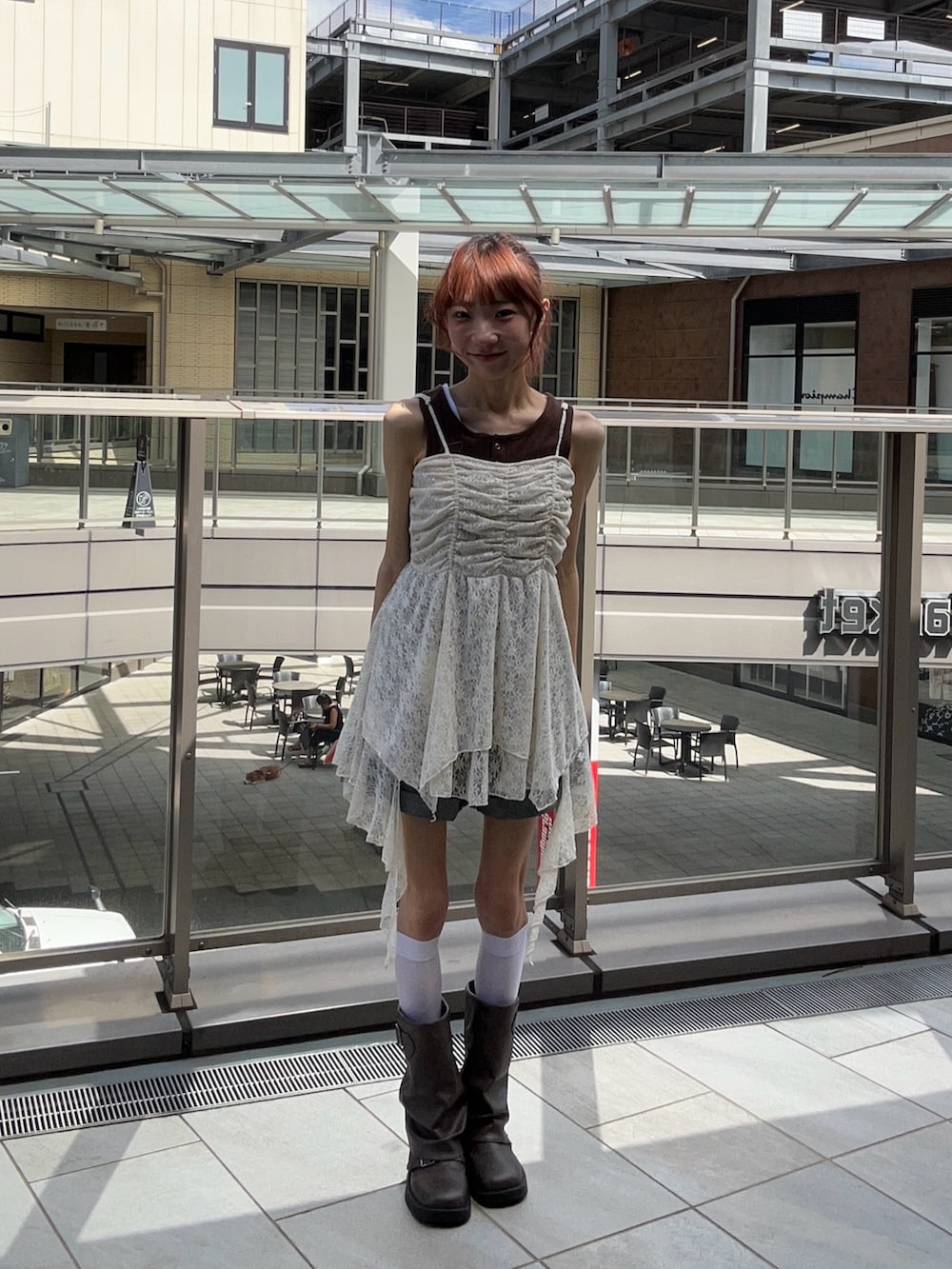 ベージュ系のチュニック、ブラウン系のタンクトップ、ブルー系のその他パンツを着用したレディースの夏コーディネートの2枚目の写真