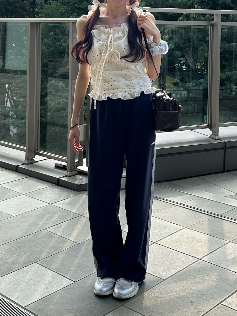 ブルー系のスウェットパンツ、ホワイト系のシャツ/ブラウス、シルバー系のスニーカーを着用したレディースの夏コーディネートの2枚目の写真