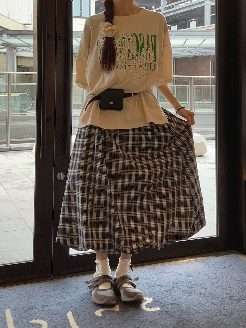 ブルー系のスカート、ベージュ系のTシャツ/カットソー、グレー系のスニーカーを着用したレディースの夏コーディネートの3枚目の写真