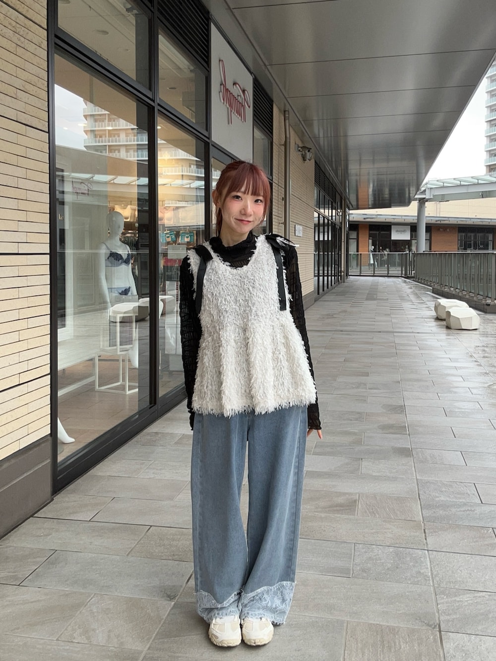 ホワイト系のベスト、ブラック系のTシャツ/カットソー、ブルー系のデニムパンツを着用したレディースの秋コーディネートの3枚目の写真