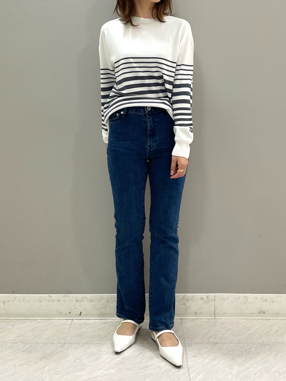 グレー系のニット/セーター、ブルー系のデニムパンツ、その他のその他を着用したレディースの春コーディネートの2枚目の写真