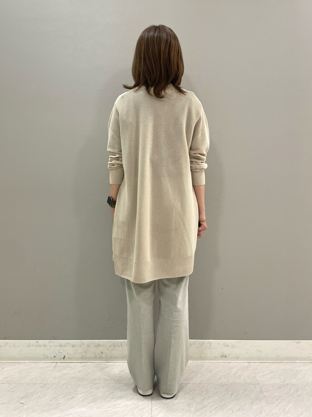 グリーン系のTシャツ/カットソー、ベージュ系のカーディガン/ボレロ、グレー系のスーツパンツを着用したレディースの春コーディネートの4枚目の写真