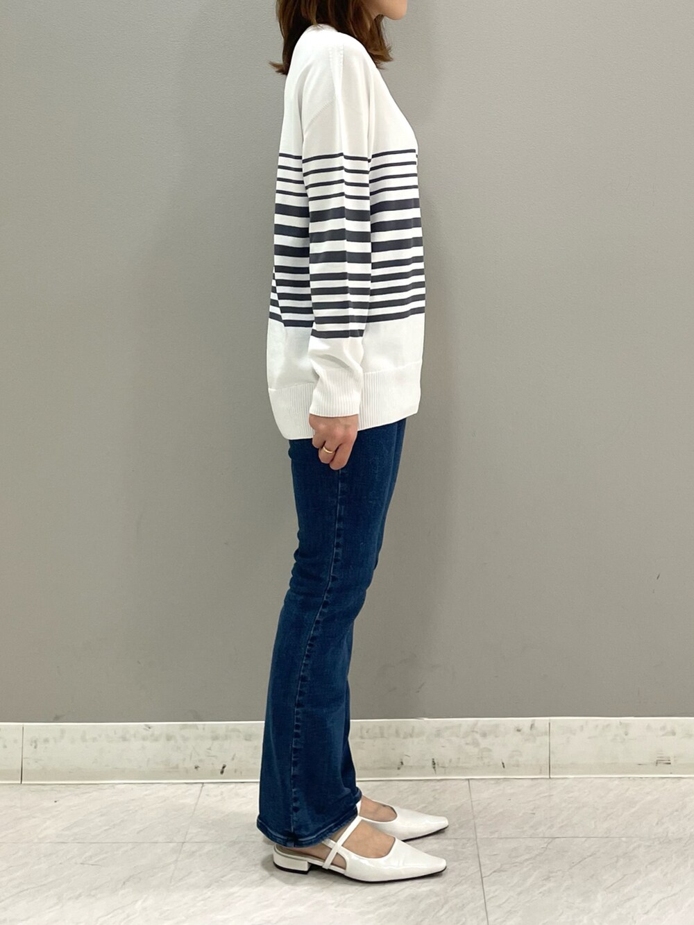 グレー系のニット/セーター、ブルー系のデニムパンツ、その他のその他を着用したレディースの春コーディネートの3枚目の写真