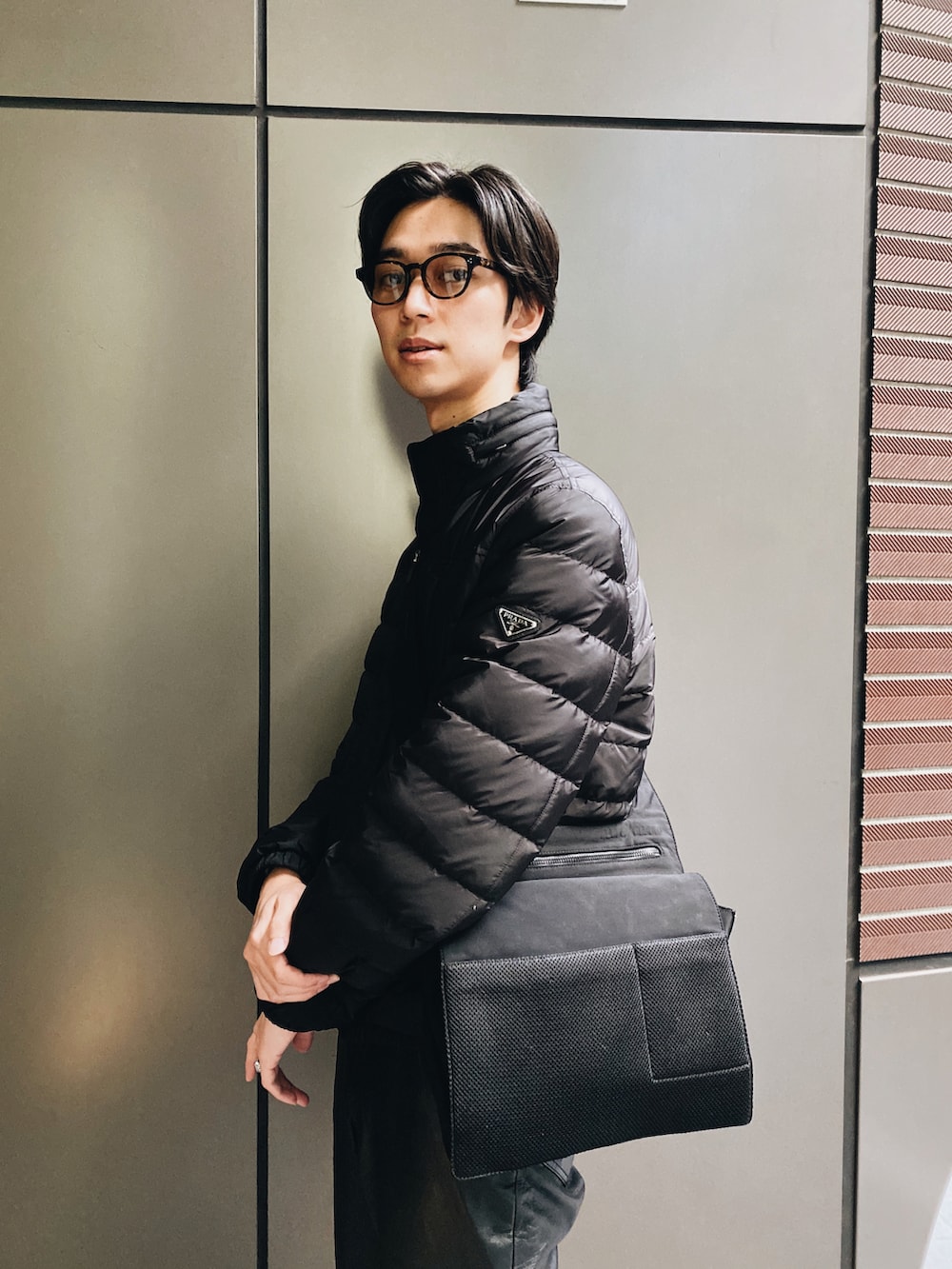 「冬コーデ、おしゃれさんと繋がりたい、ブラックコーデ、シンプルコーデ、オールブラック、モード、ダウンジャケット、PRADA、MIUMIU、yohjiyamamoto」｜「PRADAのアイテム（ダウンジャケット/コート、ブラック系）」を使った、高瀬信人さん（メンズ・184cm）の冬コーディネートの3枚目の写真