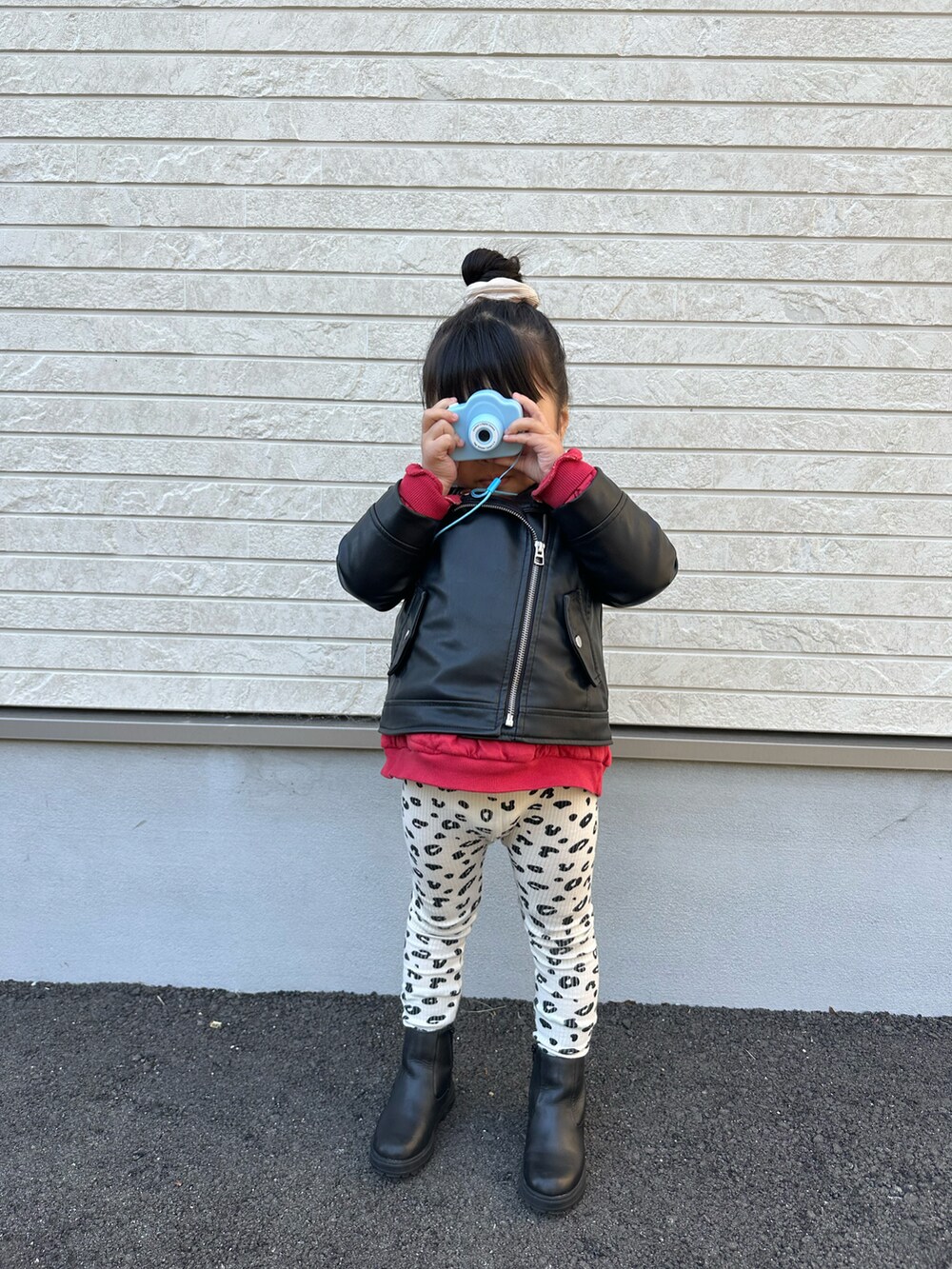 ブラック系のライダースジャケット、レッド系のスウェット、ブラック系のブーツを着用したキッズの春コーディネートの2枚目の写真