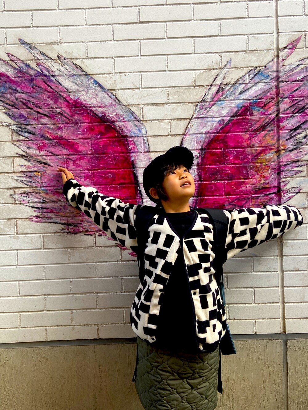 ブラック系のカーディガン/ボレロ、グリーン系のスカート、ブラック系のパンツを着用したキッズの冬コーディネートの2枚目の写真