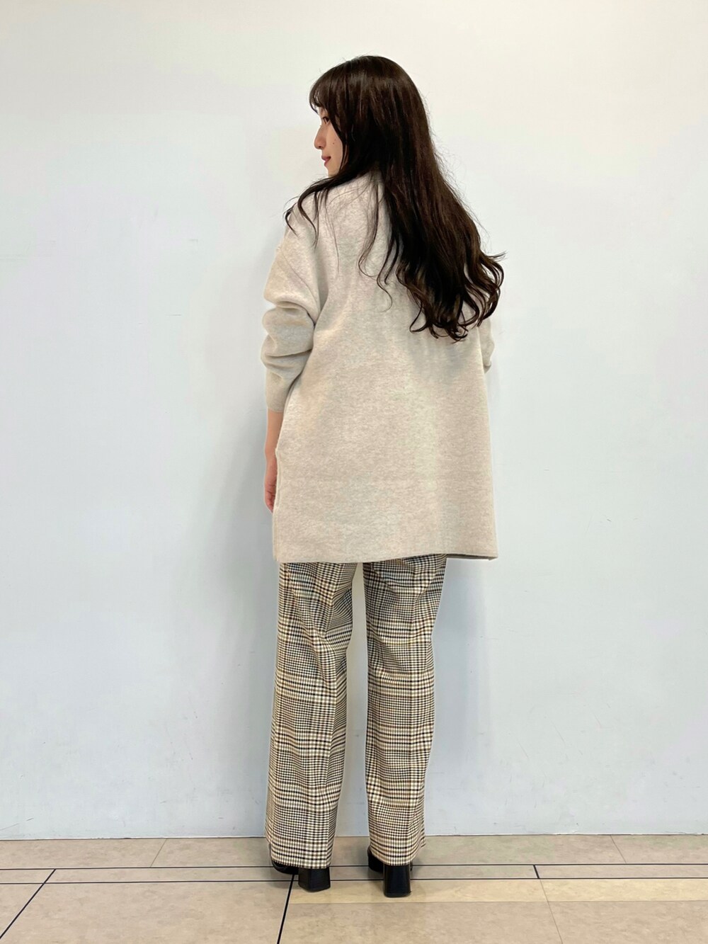 ベージュ系のカーディガン/ボレロ、ホワイト系のニット/セーター、ホワイト系のスニーカーを着用したレディースの秋コーディネートの5枚目の写真