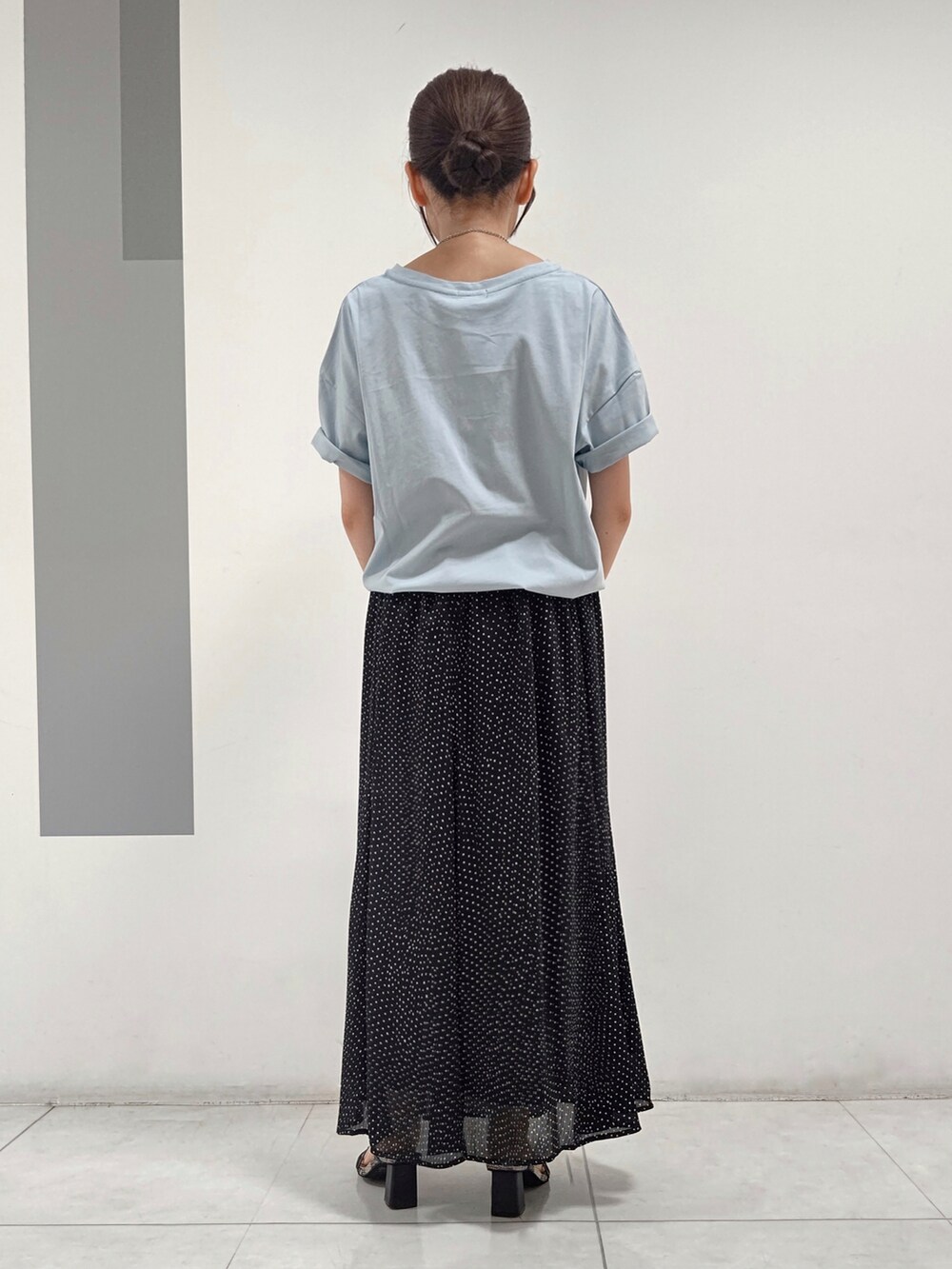 ブルー系のTシャツ/カットソー、ブラック系のスカート、ホワイト系のショルダーバッグを着用したレディースの夏コーディネートの3枚目の写真