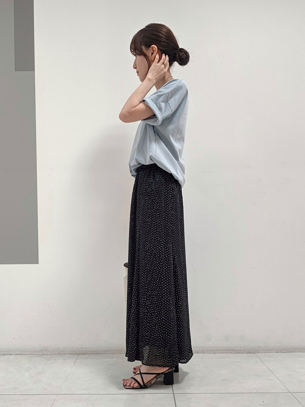 ブルー系のTシャツ/カットソー、ブラック系のスカート、ホワイト系のショルダーバッグを着用したレディースの夏コーディネートの2枚目の写真